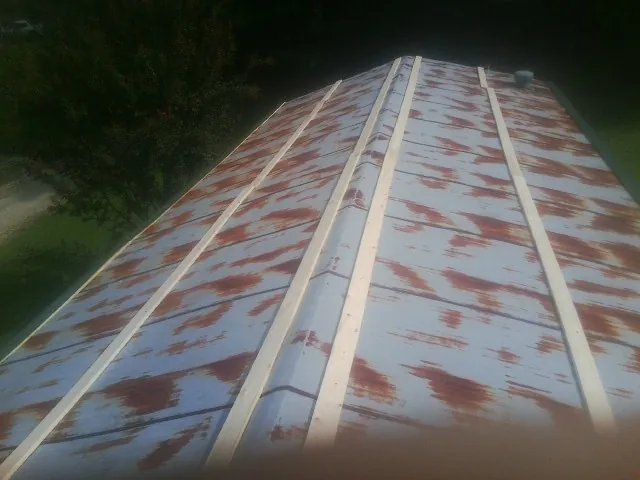 Rusted metal roof panels with new wood purlins before replacement — Storm Damage Roof Repair in Atlanta by Roofing Brothers