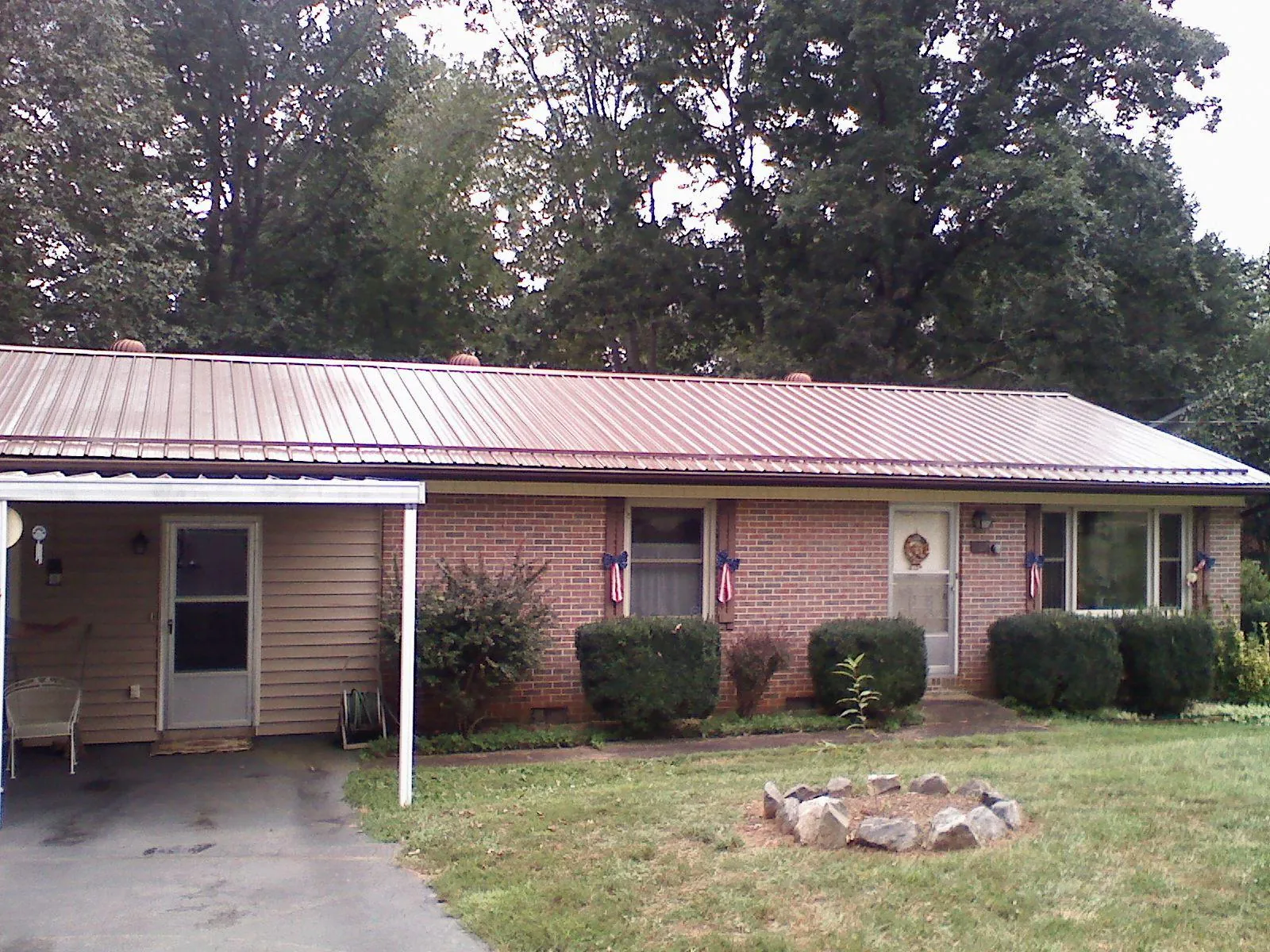 Bronze metal roof and carport on a brick ranch home — Roof Repair work by our crew in Atlanta